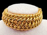 an image of a close up of a gold bracelet on a mannequin