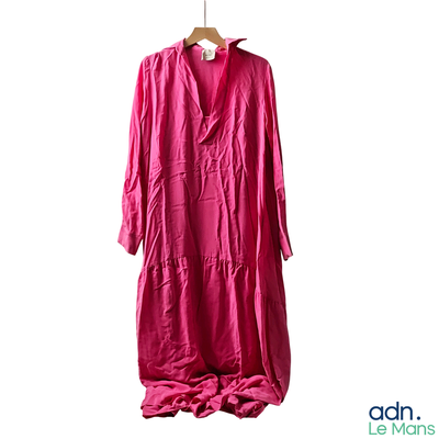 pink long dress hanging on a hanger on a white wall