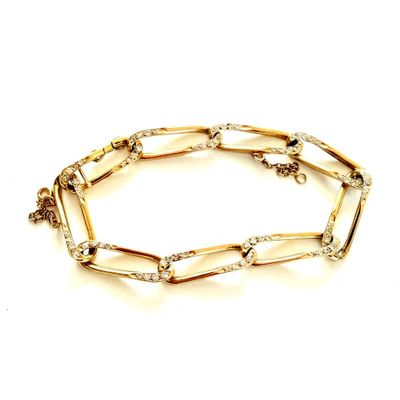 gros plan d'un bracelet en or sur fond blanc