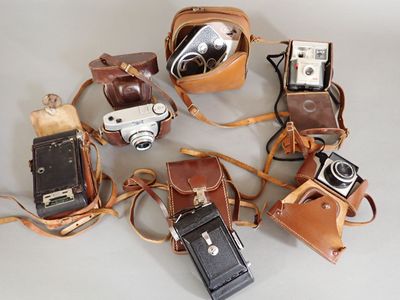 a lot of different types of cameras on the table
