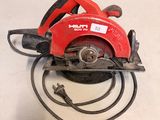 an image of a red circular saw sitting on top of a table