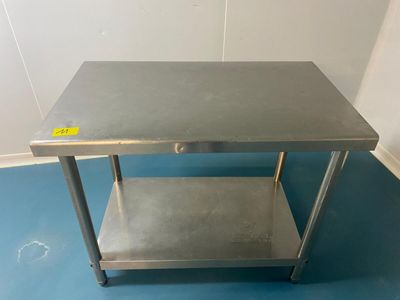 une table en acier inoxydable avec une étagère en dessous, posée sur un sol bleu