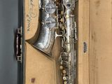 a silver saxophone in a box with a note on it