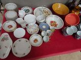 une table rouge sur laquelle sont posés plusieurs assiettes et bols
