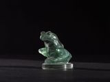 a close up of a statue of a frog on a black surface