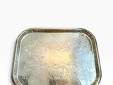 une image représentant un plateau en argent posé sur une surface blanche