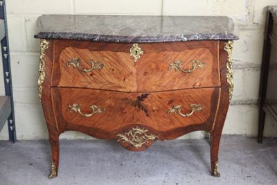a marble top chest of drawers on display in a room