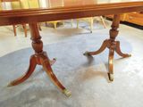 a wooden table with a glass top and gold legs