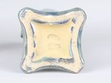 a close up of a blue and white vase on a white surface