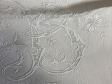 a close up of a white table cloth with a floral design on it