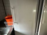 a refrigerator and a sink in a small kitchen