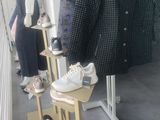 mannequins in a clothing store with a coat and shoes on display