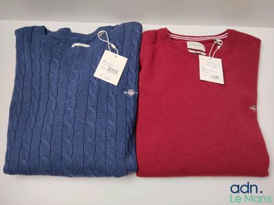 deux pulls, un rouge et un bleu, posés sur une table avec une étiquette de prix