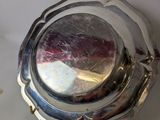 a silver plate with a silver lid on a table
