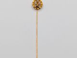 a close up of a gold and diamond broochle on a stick