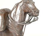 a bronze statue of a horse with a saddle on it