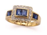 a close up of a blue sapphire and diamond ring on a white background