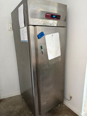 a stainless steel refrigerator in the corner of a room