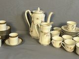 de nombreuses tasses et soucoupes ainsi qu'une théière posées sur une table