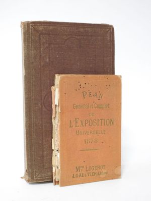 an old book sitting on top of a table next to a brown book