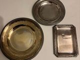 three silver plates and a silver tray on a table