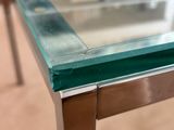 a close up of a glass table with a metal frame