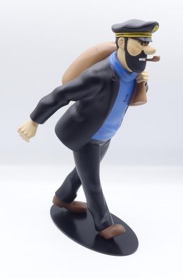 figurine représentant un homme en costume portant un sac sur une planche de surf