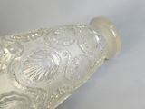 une bouteille en verre transparent avec un bouchon blanc posée sur une table