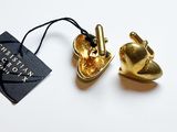 un petit objet en or auquel est attachée une étiquette