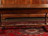 a wooden table with a wooden top on a red rug