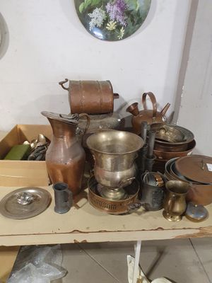 de nombreuses casseroles et poêles posées sur une table dans une pièce