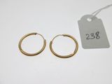 deux paires de boucles d'oreilles en or sur fond blanc