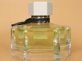 an image of a bottle of perfume on a brown background