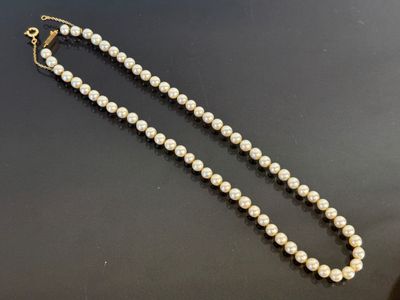 a white pearl necklace on a black surface