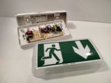 a green and white emergency sign and a white box with a green sign