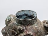 a small vase with a face on it sitting on a table