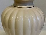 a white vase with a lid sitting on a table