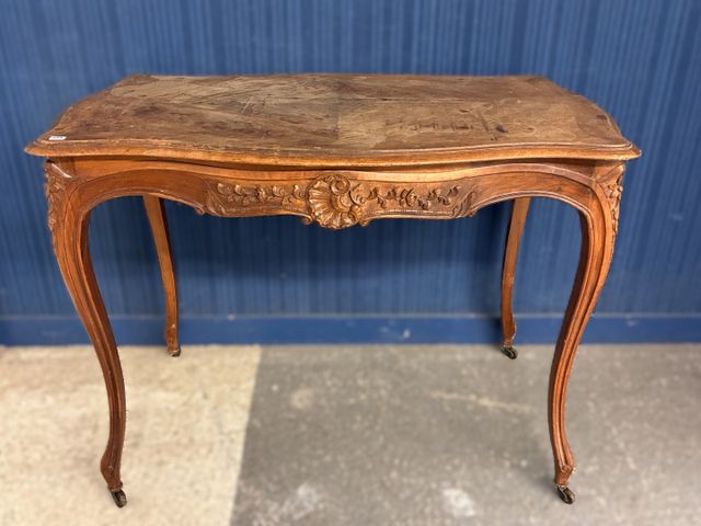 Table de milieu en noyer sculpté, de style Louis XV, reposant sur...