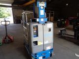 a blue and silver lift truck in a garage