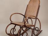 un fauteuil à bascule avec une assise en osier sur fond blanc