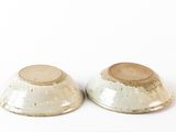 two bowls that are sitting on a white surface