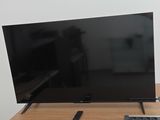 une télévision à écran plat posée sur une table en bois