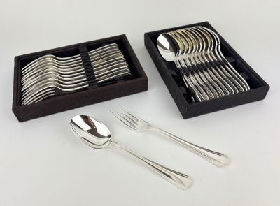 a set of silverware in a black box on a white table