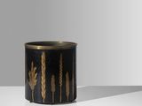 une jardinière noire et dorée posée sur une table blanche