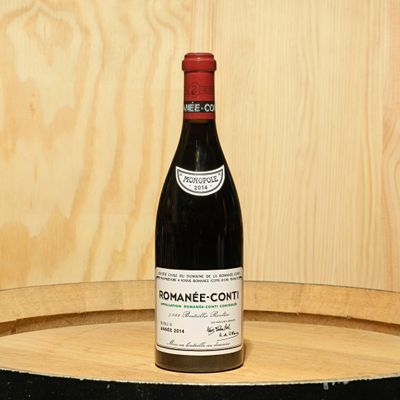 a bottle of wine sitting on top of a barrel