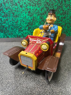 une figurine représentant un homme au volant d'une petite voiture
