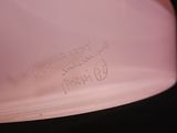 a pink bowl with writing on it sitting on a table