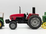 three toy tractors sitting next to each other on a white surface