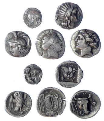 a close up of a group of ancient coins with faces on them