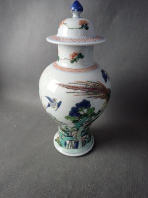 un vase blanc muni d'un couvercle orné de fleurs et d'oiseaux